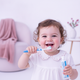 Portrait of a happy, smiling toddler with a joyful and carefree expression, against a bright white background with soft laven